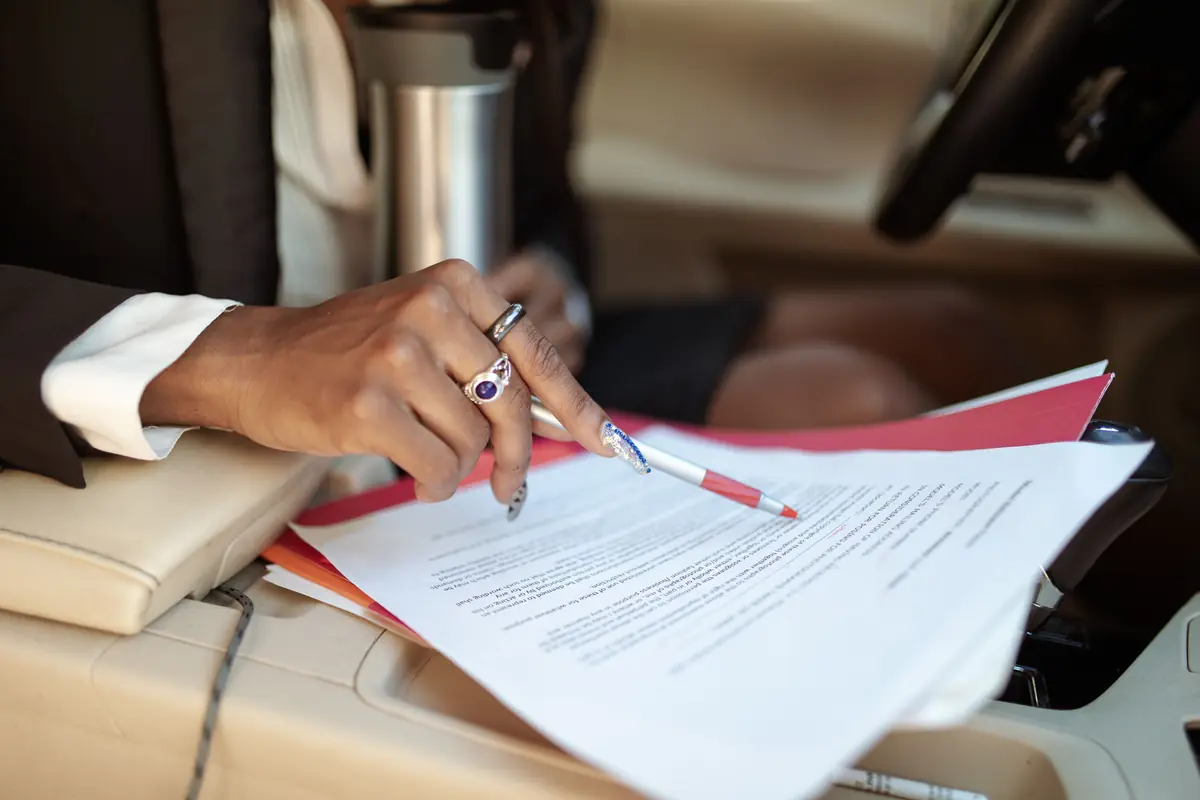 Checking a rental agreement with a pen, inside a car