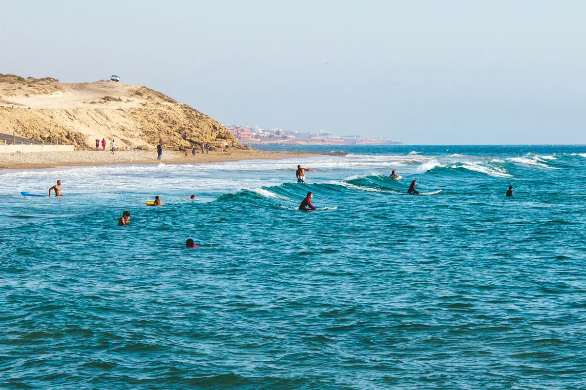 Surfers in the turquoise water at Tamraght, near Agadir